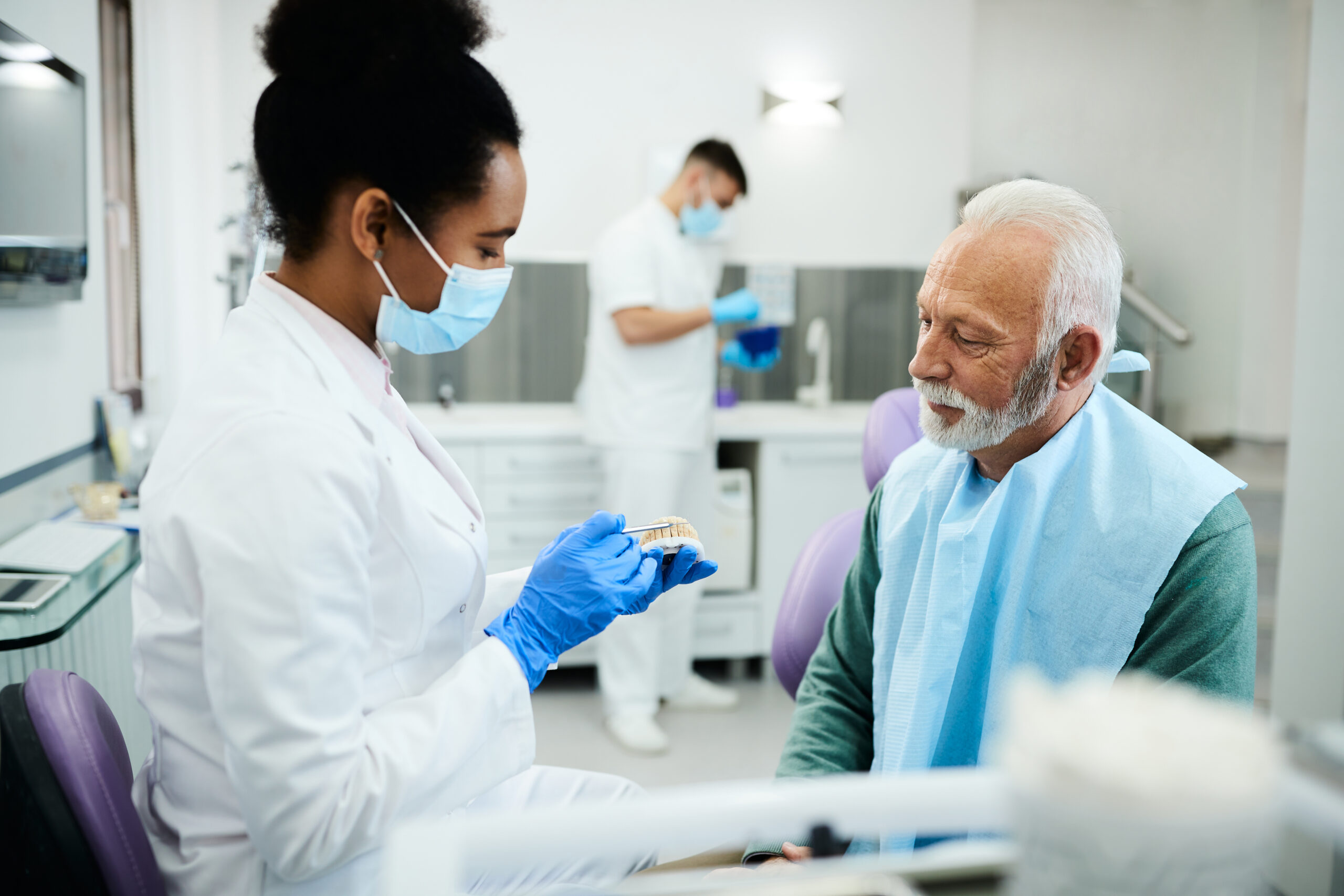 Dentist discussing denture options with a patient during prosthodontic consultation