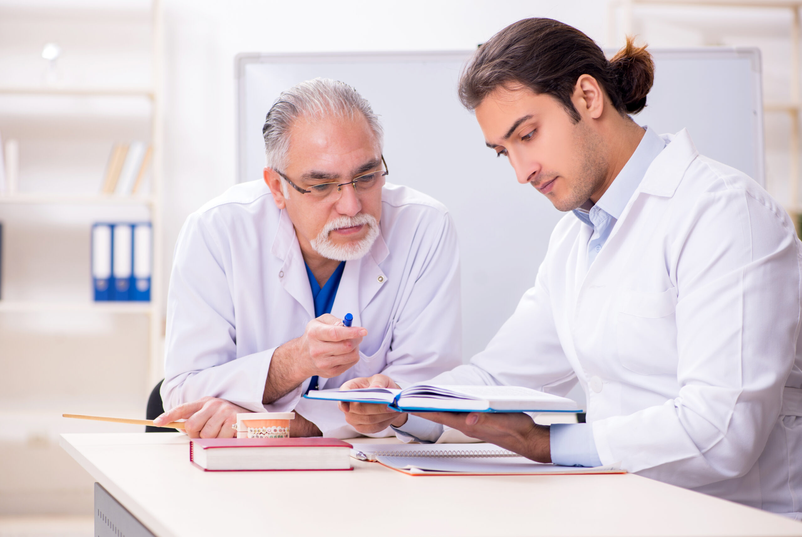 Experienced dentist teaching advanced clinical techniques to dental professional